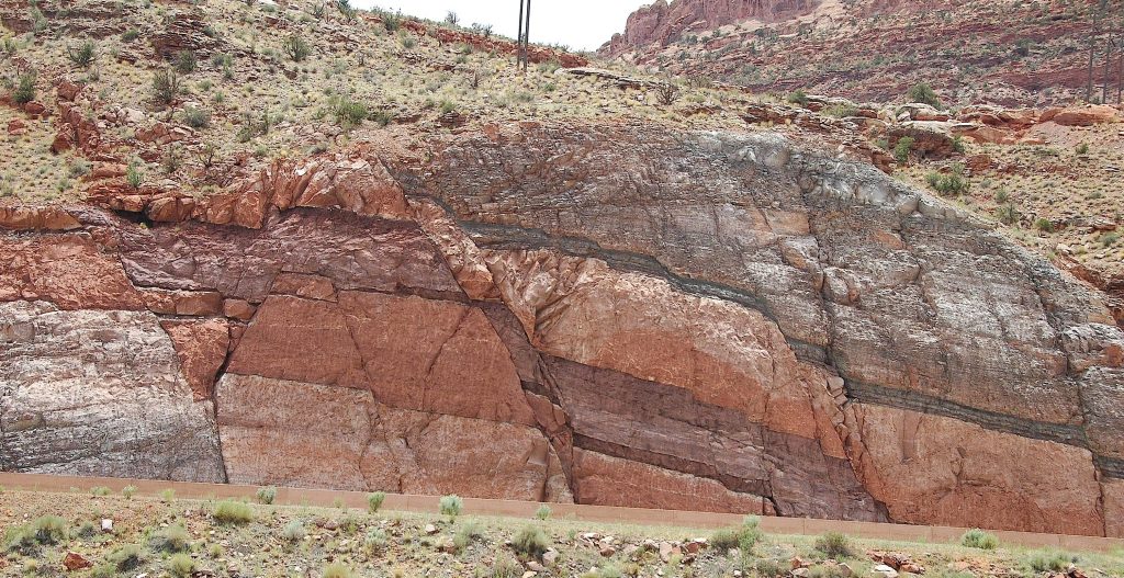 Roadcut outcrop of multicolor rock beds offset by a normal fault.